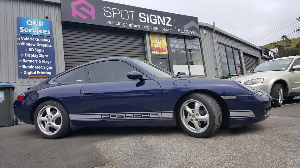 Blue Porsche with Porsche side decals outside the Spot Signz Auckland workshop
